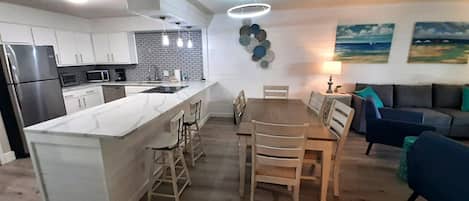 Una cocina moderna con una isla central, una mesa de comedor y sillas.