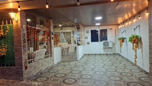 L’entrée d’un hôtel, avec un sol carrelé à motifs, un portail en métal et des plantes décoratives.