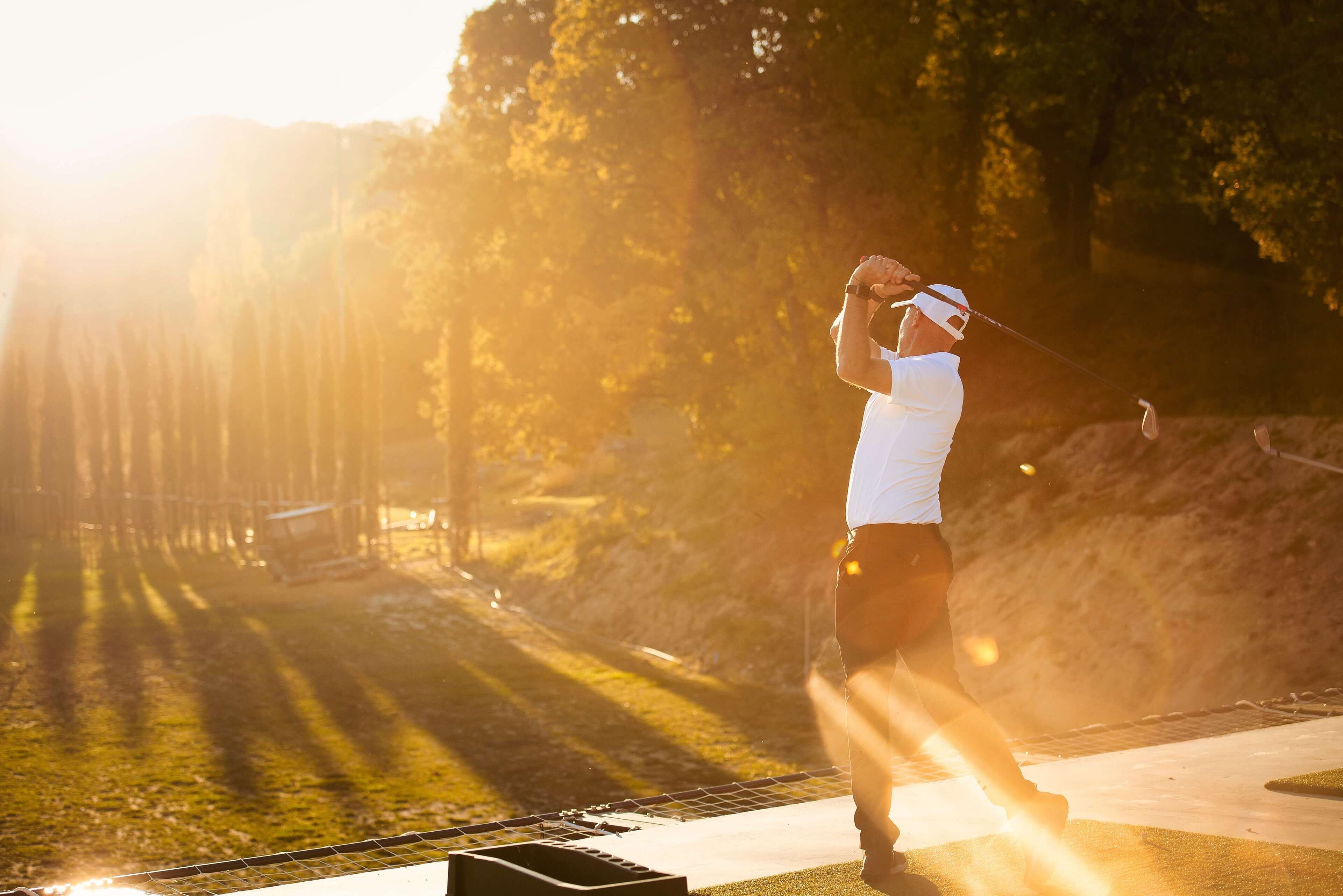 Una persona jugando al golf en un día soleado.