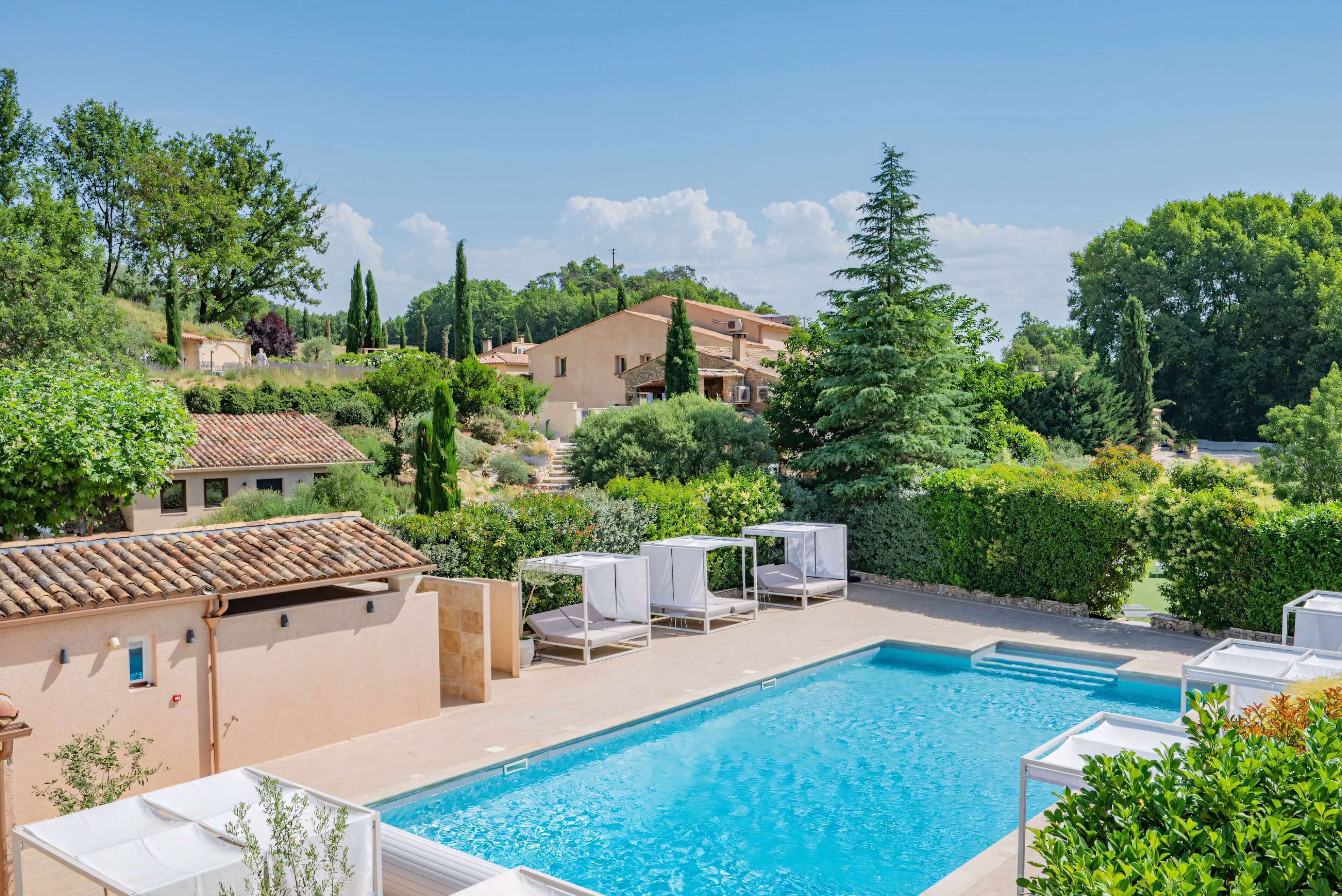 A swimming pool with lounge chairs and a view of the surrounding landscape.