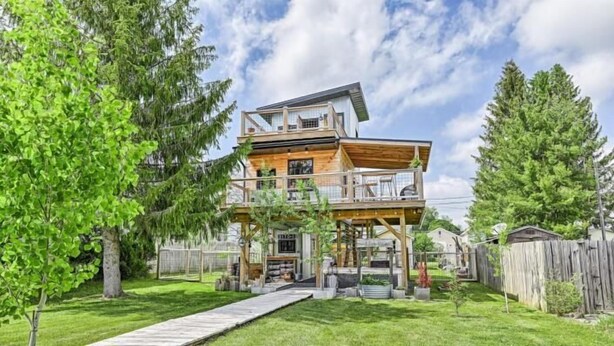 A two-story wooden house with a covered porch and a small deck. - Zen2- Adorable Tiny Home in Davis! Pet Friendly! A/C (Davis)