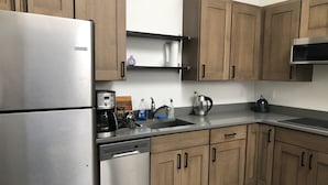Una cocina moderna con armarios de madera, electrodomésticos de acero inoxidable y lavavajillas integrado.