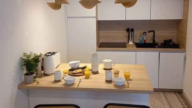 Eine moderne Küche mit einer Holzinsel, Pendelleuchten und einem eingebauten Backofen.