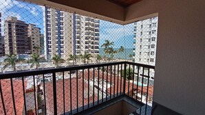 Ein Balkon mit einem Drahtzaun, der auf einen Parkplatz und Gebäude mit roten Ziegeldächern blickt.
