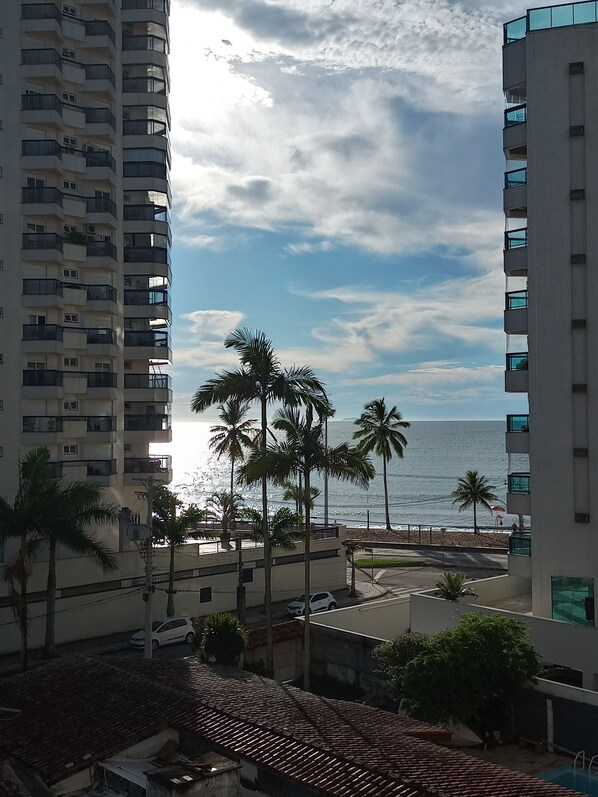 A high-rise building with balconies overlooking a beach.