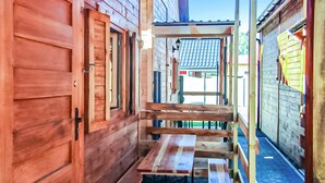A wooden cabin with a wooden bench and a door.