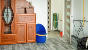 Ein Zimmer mit einem Holzschrank, einem blauen Mülleimer und einer Heizung.