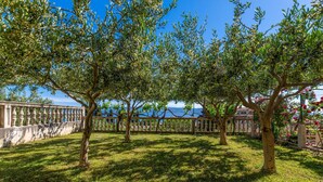A garden with a stone balustrade, trees, and a view of the sea. - Awesome apartment in Duce with WiFi (Duce)