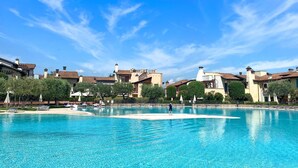 Ein großer Außenpool mit klarem, blauem Wasser, umgeben von Gebäuden im mediterranen Stil.