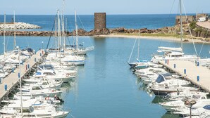 A marina with numerous boats docked in calm waters, a clear sky, and a rocky shoreline. - 2 bedroom nice home in Castelsardo (Castelsardo)