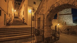 A stone staircase leading to a building entrance, with a metal gate and a stone wall on the right. - 2 bedroom nice home in Castelsardo (Castelsardo)
