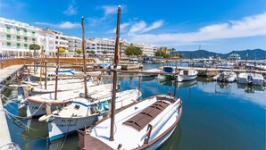 A marina with multiple boats docked, a hotel named "Hotel Cala Bona" in the background, and a clear blue sky. - Awesome home in Cala Bona (Cala Bona)