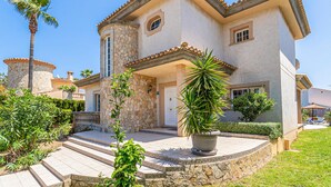 A two-story house with a stone facade, a tiled roof, and a front porch with steps leading to the entrance. - Awesome home in Cala Bona (Cala Bona)
