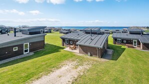 A row of modern cabins with a grassy yard and a view of the sea. - Stunning home in Faaborg with WiFi (Faaborg)