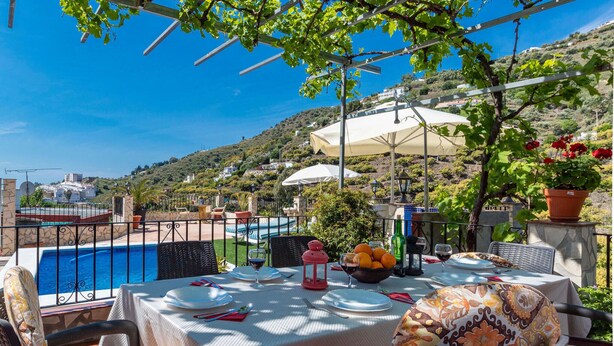 An outdoor dining area with a pool view, tables set for dining, and a scenic hillside backdrop. - Gorgeous home in Torrox with WiFi (Torrox)