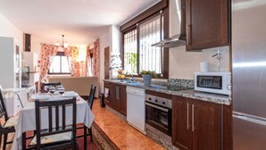 A compact kitchen with wooden cabinets, a built-in oven, and a microwave. - Gorgeous home in Torrox with WiFi (Torrox)