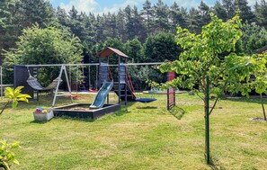 Ein Spielplatz mit Schaukeln, Rutschen und einer Kletterkonstruktion.
