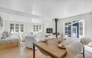 Relax in this stylish living area with a fireplace, dining table for two, and comfortable seating.
