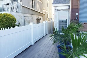 A residential building with a white picket fence, a potted plant, and a door marked with the number 405. - Modern Beachfront Suite 309 (Ocean City)