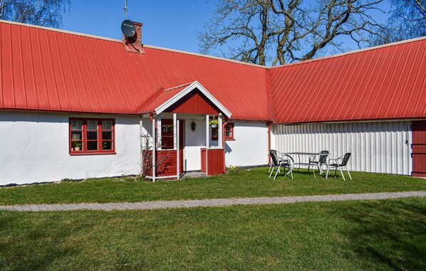 A red and white building with a small porch and outdoor seating area. - Awesome apartment in Nybrostrand (Nybrostrand)