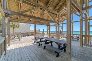 Eine Holzterrasse mit Picknicktischen und Blick auf den Ozean.