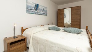 A bedroom with a bed, bedside table, lamp, and a painting on the wall. - Gorgeous apartment in Pula with WiFi (Pula)