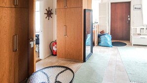 A hallway with wooden cabinets, a fire extinguisher, and a blue bag on the floor. - Gorgeous apartment in Målilla with WiFi (Målilla)