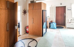 A hallway with wooden cabinets, a fire extinguisher, and a blue bag on the floor. - Gorgeous apartment in Målilla with WiFi (Målilla)