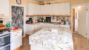 A compact kitchen with white cabinets, a stove, and a patterned tablecloth. - Gorgeous apartment in Målilla with WiFi (Målilla)