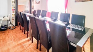 A dining area with a long table, multiple chairs, and a vacuum cleaner near the entrance. - Gorgeous apartment in Målilla with WiFi (Målilla)