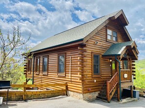 Cozy cabin with a spacious porch and large windows, offering a peaceful retreat.
