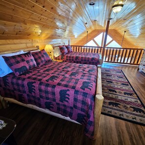 Cozy bedroom with a large bed, nightstand, and patterned rug.