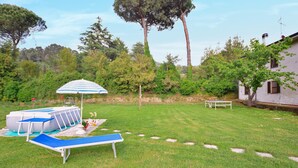 Un patio trasero con piscina, una sombrilla, una banca y una mesa.