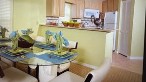 A compact kitchen with wooden cabinets, a microwave, and a refrigerator.