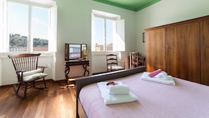 A room with a bed, a rocking chair, a desk, and a wardrobe. - Lungarno attic with private terrace and lift (Firenze)