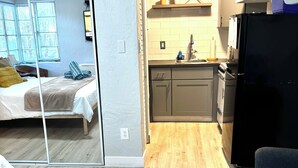 Um espaço compacto com quarto, cozinha americana e área de refeições.
