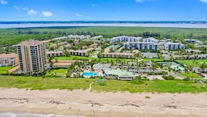 Ein Küstenresort mit mehreren Gebäuden, einem Strand und einem Poolbereich.
