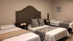 A hotel room with three beds, a wooden headboard, and a bedside table with a lamp. - Hermosa Habitacion en Getsemani (Cartagena de Indias)