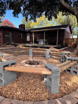A brick building with a covered patio, outdoor seating, and a fire pit area. - Displaced Families Ready | Sleeps 10 | Pets OK | EV Charger (Decatur)