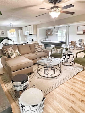 A living room with a sectional sofa, a round coffee table, and a ceiling fan. - Displaced Families Ready | Sleeps 10 | Pets OK | EV Charger (Decatur)