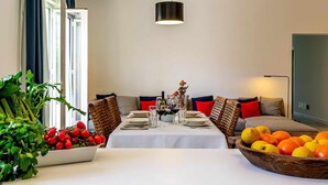 Un espace repas avec une table dressée pour quatre personnes, entourée de sièges confortables.