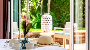 Une table avec un vase de fleurs, un chapeau et un plateau contenant des tasses et une théière.