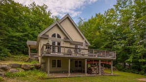 A two-story house with a balcony, surrounded by a wooded area. - Walk to pond / playground in pet friendly chalet while enjoying mountain views (Madison)