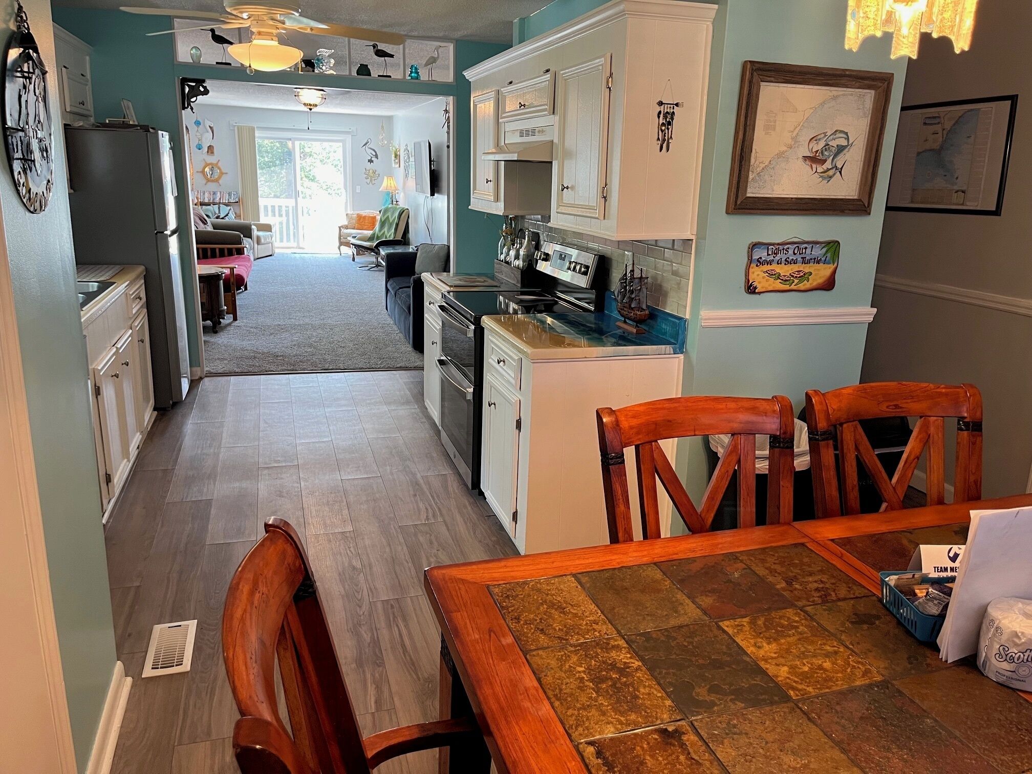 A kitchen with a dining area, wooden chairs, and a table.