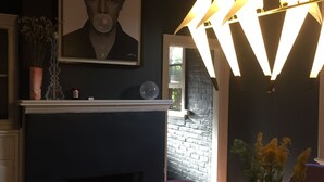 A dining area with a marble table, a fireplace, and a modern pendant light fixture. - Historical terrace house in the middle of Fitzroy (Fitzroy)