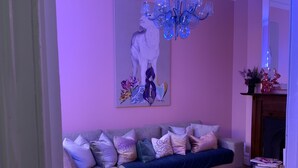 A living room with a sofa, ottoman, and a chandelier. - Historical terrace house in the middle of Fitzroy (Fitzroy)