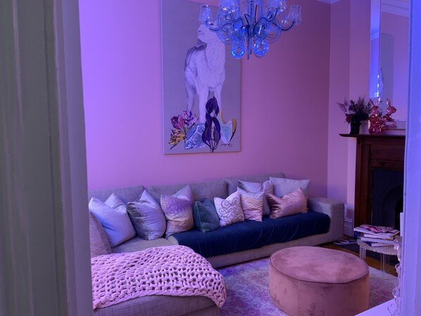 A living room with a sofa, ottoman, and a chandelier. - Historical terrace house in the middle of Fitzroy (Fitzroy)
