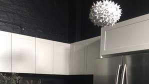 A kitchen with white cabinets, a stainless steel refrigerator, a gas stove, and a hanging light fixture. - Historical terrace house in the middle of Fitzroy (Fitzroy)