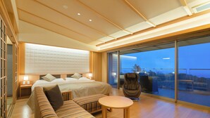 A modern hotel room with a large bed, a sofa, a small table, and a balcony with a view. - Omuro no Mori Gyokusui - 13 years or older - (Ito)