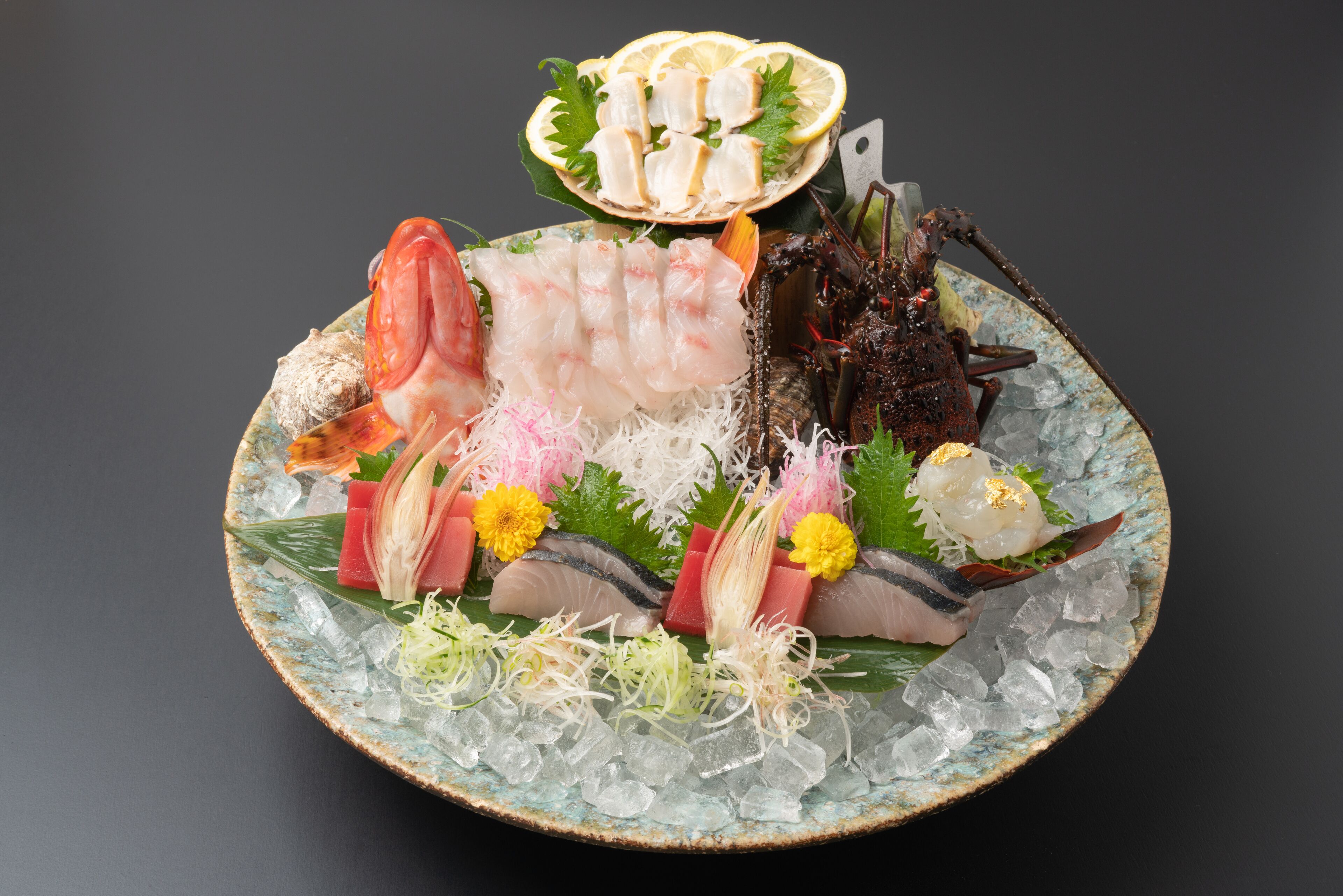 Un plateau de fruits de mer comprenant différents types de poissons et des accompagnements, le tout présenté sur un plat avec de la glace.